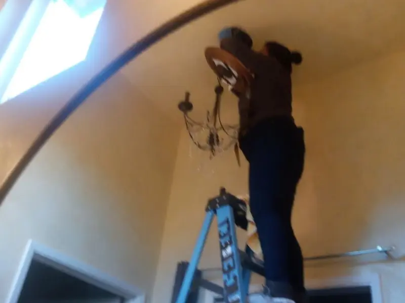 Electrician installing a chandelier in a Edmonds residence
